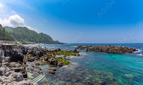 Beautiful volcanic rocky coastline and crystal clear turquoise ocean in Kozushima Island, Tokyo, Japan.