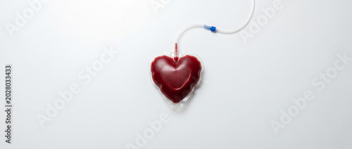 Bolsa de sangue em formato de coração isolada no fundo branco. Conceito de doação de sangue e salvar vidas.
