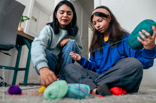 Women learning knitting with colorful yarn at home