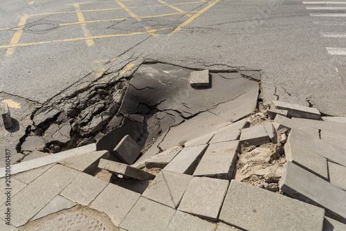 Canvastavla Collapsed asphalt and broken sidewalk blocks expose dangerous road damage at urb