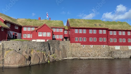 Historic government buildings at Tinganes with red wooden facades and turf roofs in Tórshavn, Faroe Islands