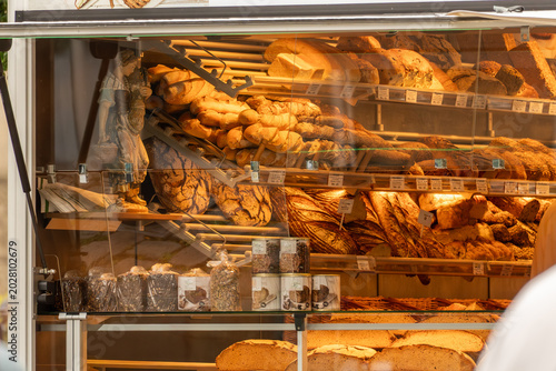 Fotografija Traditional bakery display in Germany filled with artisan breads and fresh baked goods, warm interior lighting and rustic European market atmosphere