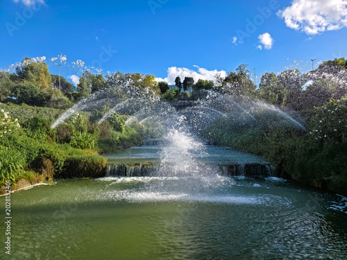 Beautiful symmetrical water jets and fountains in a modern public park, Rome EUR