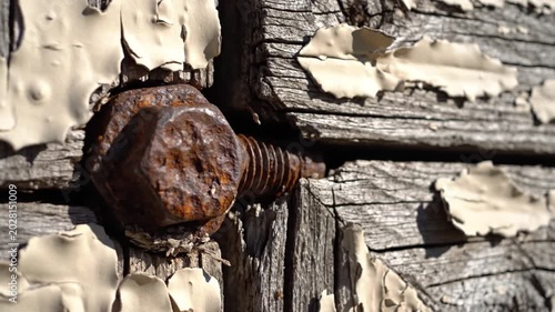 Close-Up of Rusty Bolt and Flaking Paint on Old Wood Surface 4K Footage