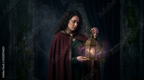 Woman in red cloak holding lantern in dark mysterious forest environment