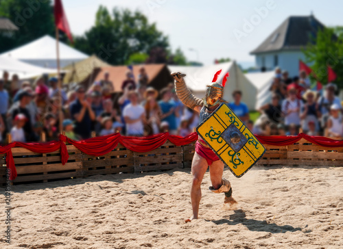 The victorious gladiator greets the audience by raising his weapon to the sky. Roman fest. Swiss Festival recreating various episodes of the daily routine of Romans. 2024 Augusta Raurica, Kaiseraugst