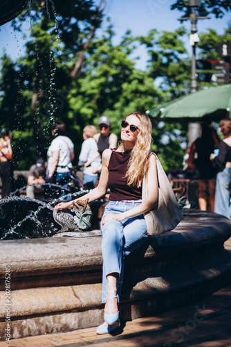 A young woman in the park by the fountain. 