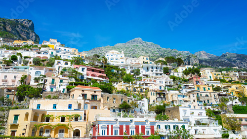 Foto Colorful houses cascaded down steep hillside under clear blue sky in Positano, Italy