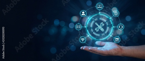 Hand holding glowing digital tech icons with wrench and tools on dark blue background with bokeh lights