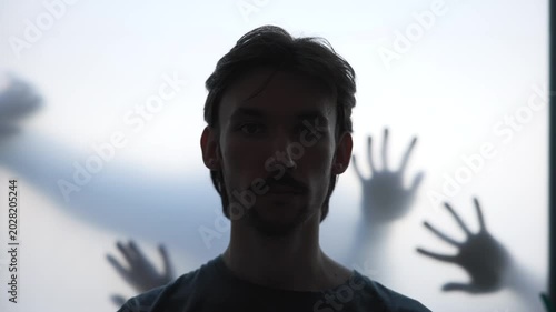 Silent Figure Confronts Unseen Hands Pressing Against Translucent Surface In Moody Setting. Media