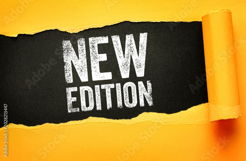 New Edition text revealed behind paper tear. Product launch, publishing, updated version, and release concept for books, software, fashion, or collectible items and upgrades