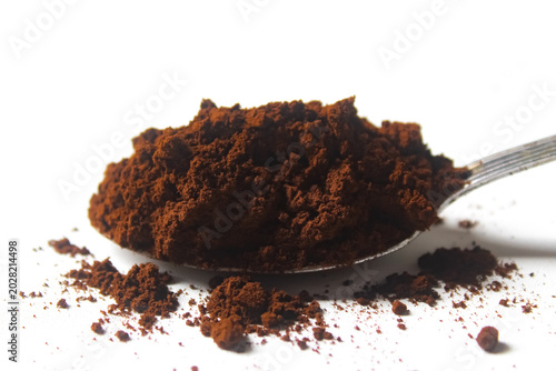 Photos a spoonful of ground coffee isolated on a white background