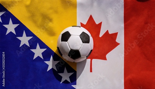 soccer ball placing between canada flag and bosnia flag