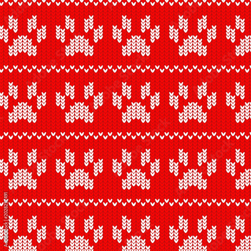 Knitted seamless pattern with paw prints on red background