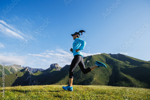 Trail runner running  on the high altitude grassland mountain top
