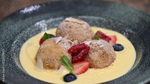 Traditional Czech fruit dumplings with fresh fruit, breadcrumbs, and vanilla sauce. Close-up of sweet homemade dessert, perfect for Czech cuisine, comfort food, and dessert photography concepts.
