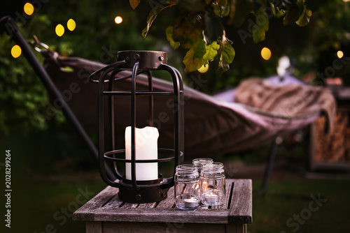 Bilde på lerret Hammock with lantern and fairy lights in evening garden setting