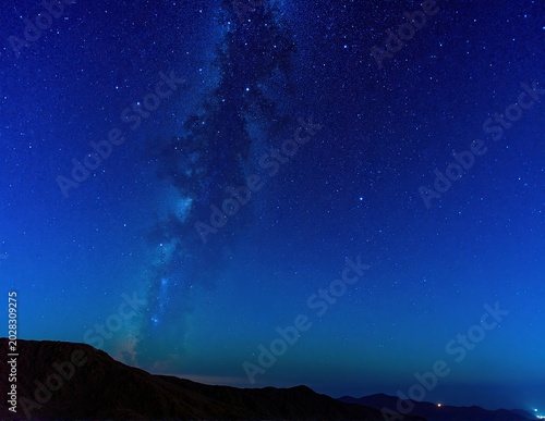 the sky is a clear, vivid blue, stretching wide and cloudless across the calm, sunlit horizon