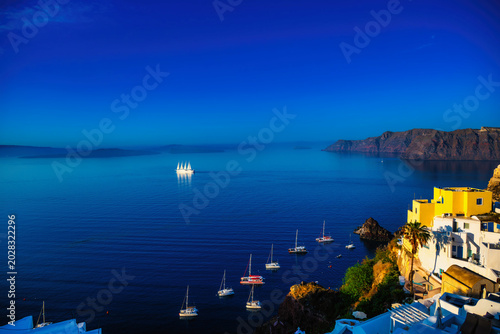 Bild auf Leinwand Blue hour Oia caldera with distant sailing ship