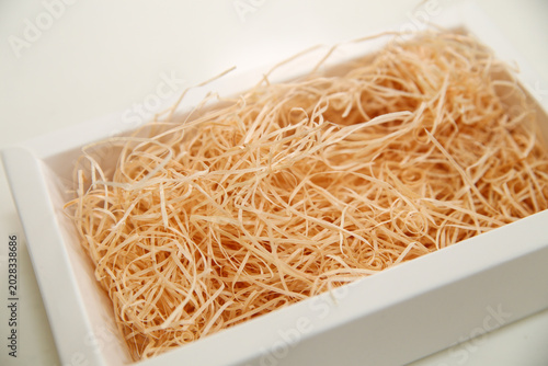 Photos White box filled with wooden excelsior cushioning material