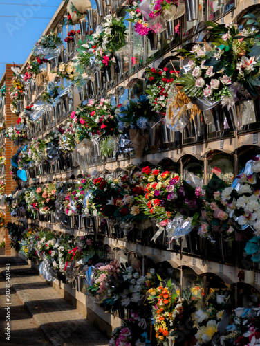 Fotografie Nichos en un cementerio con ramos de flores