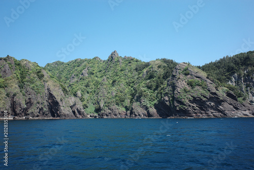 Schilderij op canvas Coastal mountains and headland viewed from the sea