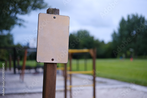 Blank sign posting in park with playground background