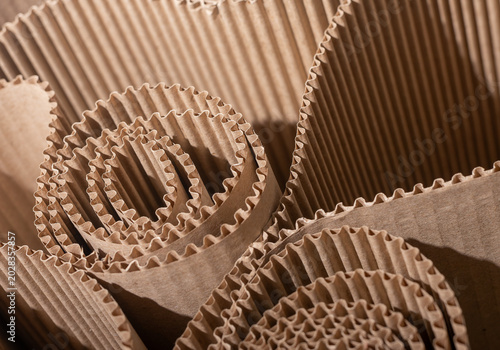Corrugated cardboard rolls in close up. Brown packaging texture with folded paper layers. Abstract industrial background for sustainable design and recycling..