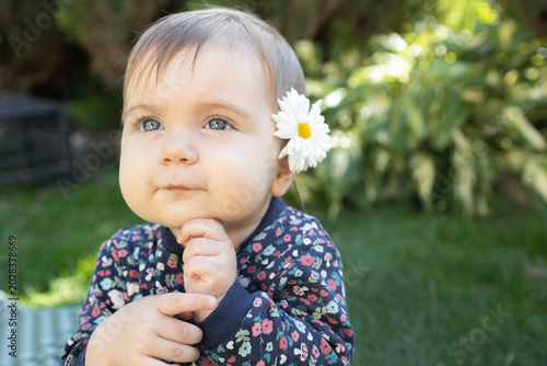 Fotografia sweet six-month-old girl with a daisy behind her ear