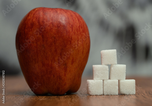 Photos Sugar in the apple, sugar cubes stacked next to the apple