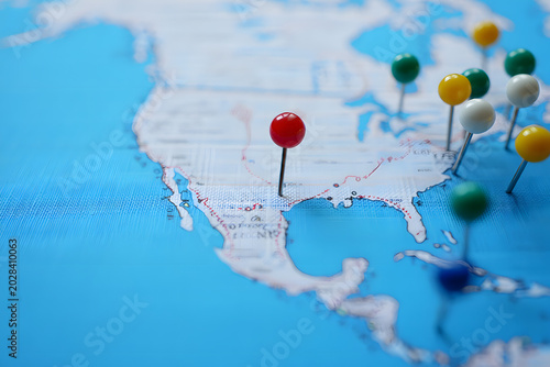 World Map Pins: A vibrant world map dotted with colorful pushpins marks various locations across North America, suggesting travel destinations, business ventures, or global exploration.