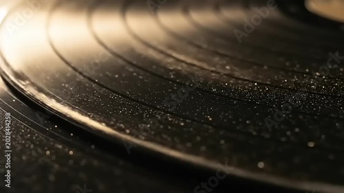 Closeup of a spinning vinyl record on a turntable capturing the grooves and reflections of light.