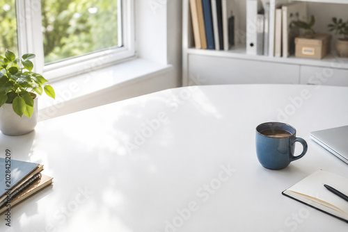 Bright minimalist office desk with summer sunlight and blue mug