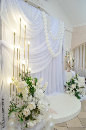 wedding photo zone made of white fabric with pearls and a candlestick