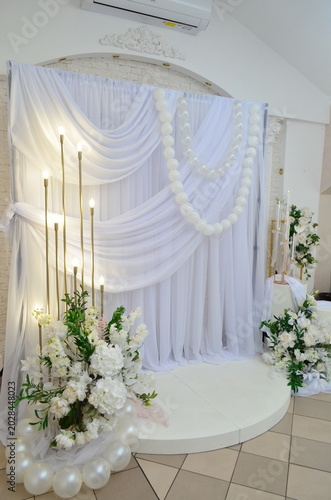 wedding photo zone made of white fabric with pearls and a candlestick