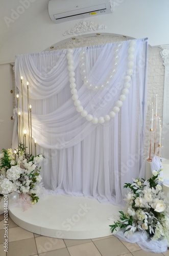 wedding photo zone made of white fabric with pearls and a candlestick