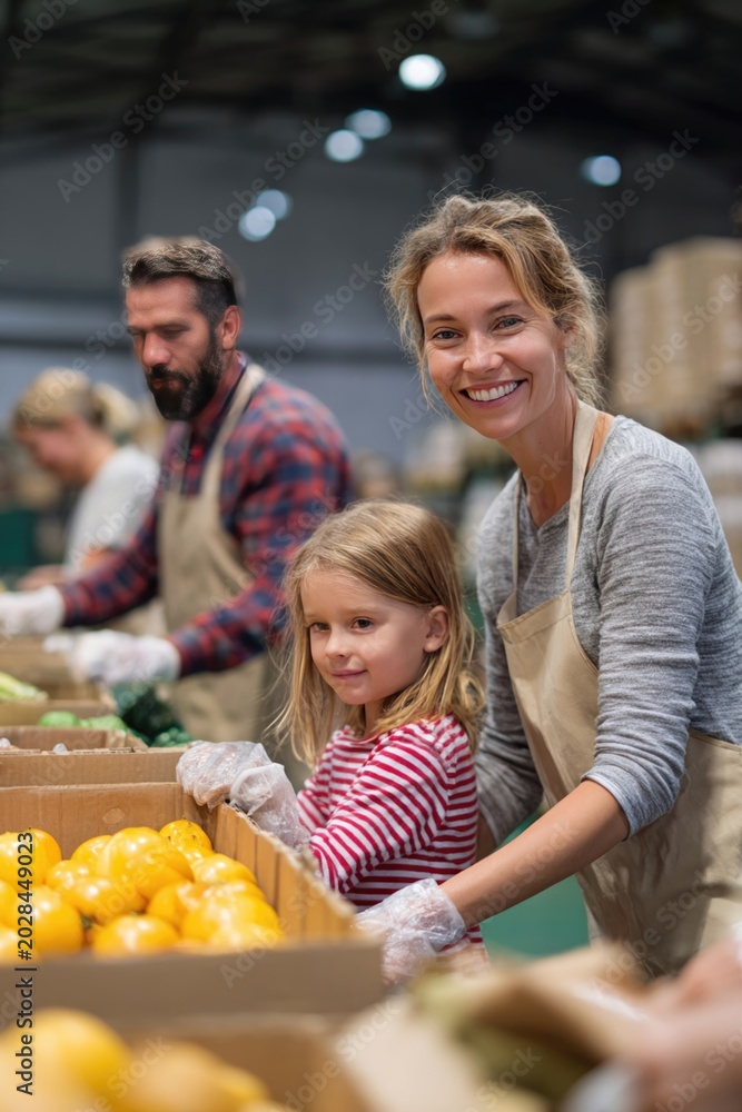 Fototapeta premium Family volunteering at a food bank together