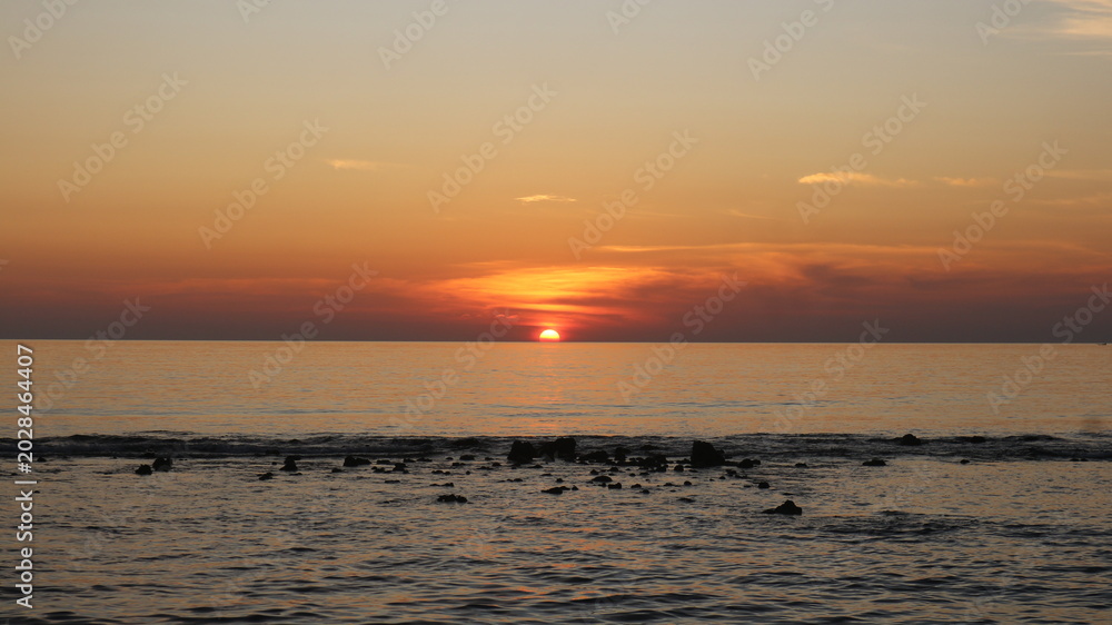 Obraz premium Sun dips low, painting sky in soft orange and pink hues