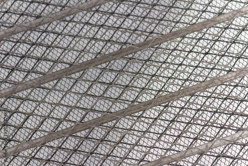 Close up of industrial dark metal mesh grid texture with diamond pattern background