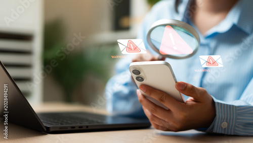 Quadro su tela Businesswoman using magnifying glass to detect spam email and cyber scam messages, representing hacker warning, spyware protection, data security, and global network cybersecurity