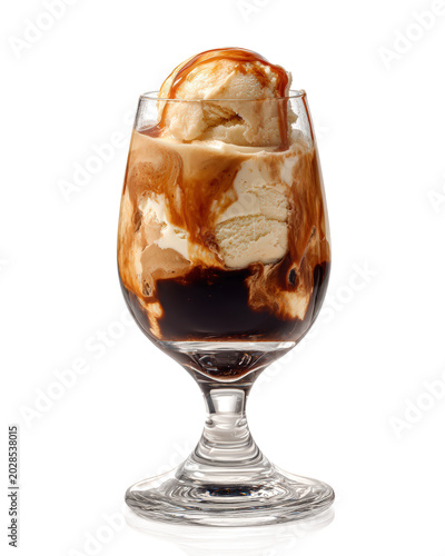 Gourmet affogato dessert with vanilla ice cream topped with sweet caramel sauce melting into hot espresso in a stemmed glass isolated on a clean studio surface