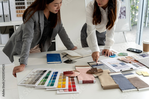 Interior Design Team Meeting Reviewing Material Samples and Color Swatches in Studio