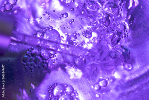 Macro view of purple anti-aging serum with air bubbles. Featuring soft focus and selective focus, this biotech beauty concept shows molecular structure and skin hydration.