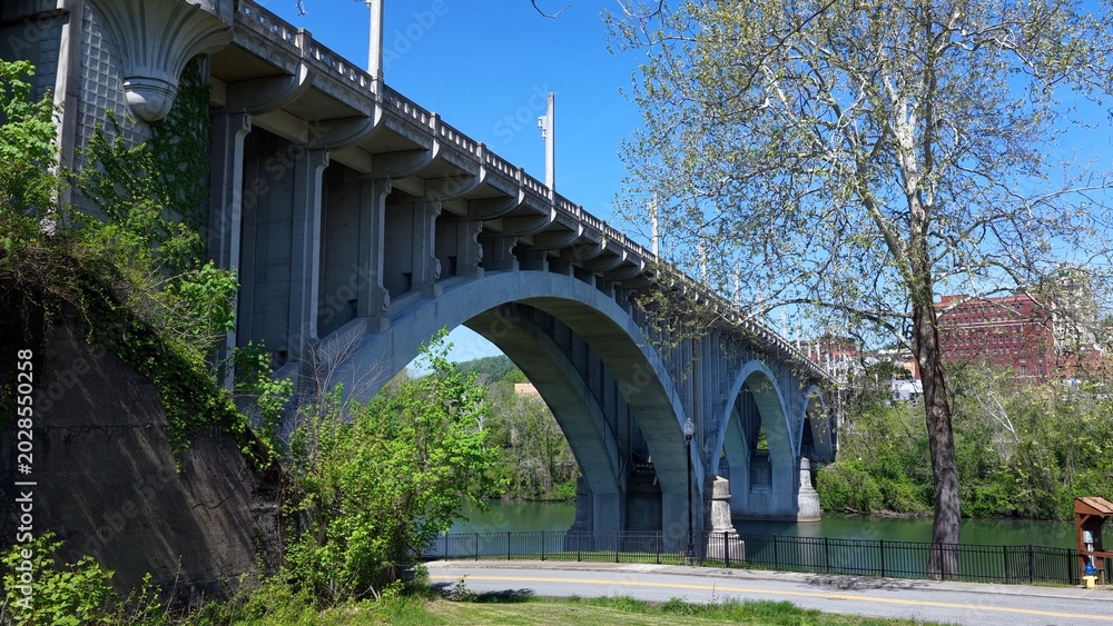 Fototapeta premium Beautiful Arched bridge crossing peaceful southern river in Fairmont, West Virginia on summer day 