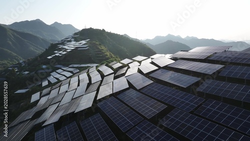 Foto Aerial view of solar photovoltaic panel arrays on mountain terraces generating c