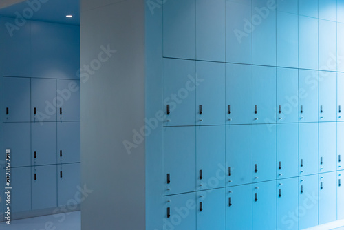 Photos A perfectly symmetrical interior photograph of a modern, minimalist locker room corridor