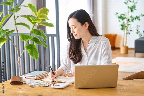 Plakat パソコンを開き家計簿を書き込む女性