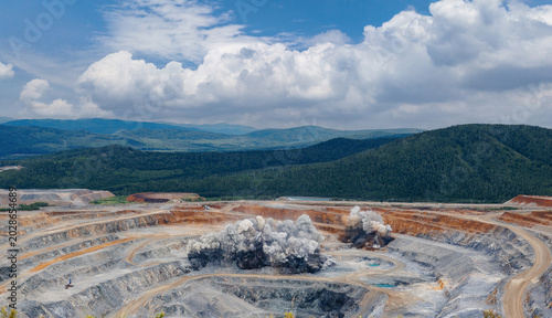 Bild auf Leinwand Explosive works on open pit gold mine industry with dust and puffs of smoke