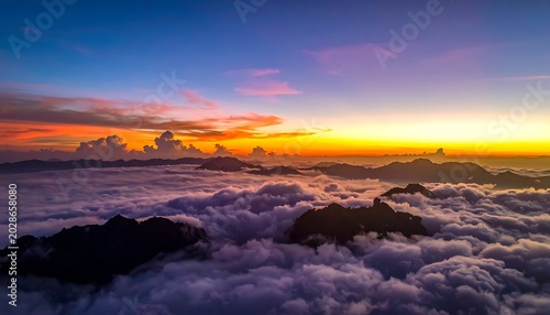 Aerial view of sunset above clouds and mountains