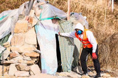 Photos Protective inspector leaning into rural makeshift dwelling
